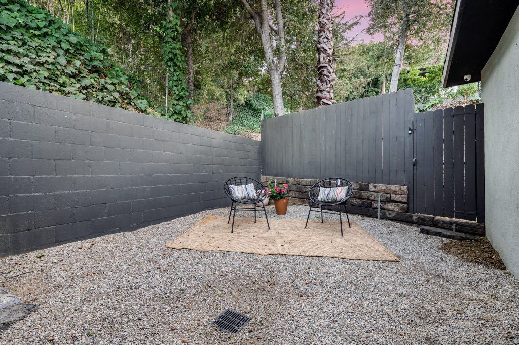 grey brick retaining wall on hill in backyard Alt description: